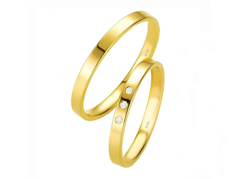 Par de anillos de boda en oro amarillo brillante, uno liso y otro con pequeñas piedras incrustadas