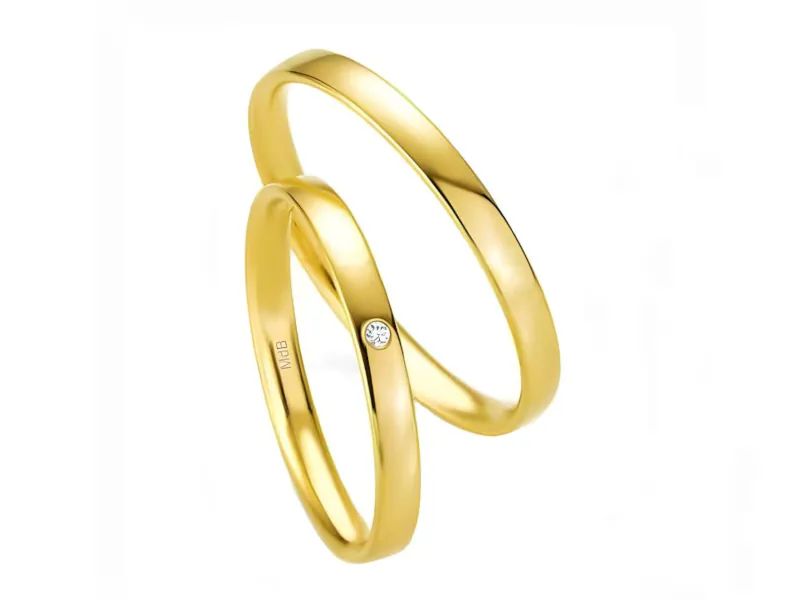 Par de anillos de boda en oro amarillo 18K, uno liso y otro con una piedra solitaria engastado