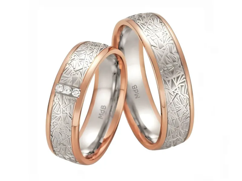 Anillos de matrimonio bicolor de oro blanco y rosa con grabado y piedras.