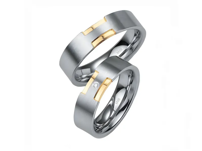 Par de anillos de boda en oro blanco con inserciones geométricas de oro amarillo; el anillo inferior incluye una pequeña piedra