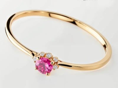 Anillo de promesa en oro amarillo 18k con piedra central rosa y pequeños piedras laterales en engaste de garras.