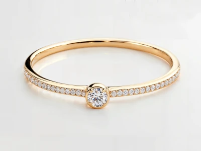 Anillo de promesa en oro amarillo 18k con piedra central y banda lateral engastada con piedras.