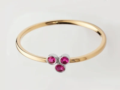 Anillo de promesa en oro amarillo 18k con tres piedras rosas engastadas en bisel, diseño delicado y moderno.