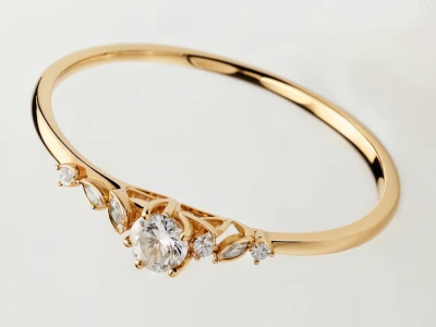 Anillo de promesa en oro amarillo 18k con piedra central redonda y piedras laterales, diseño delicado y sofisticado.