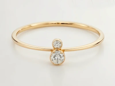 Anillo de promesa en oro amarillo 18k con dos piedras redondos en disposición vertical y diseño minimalista.