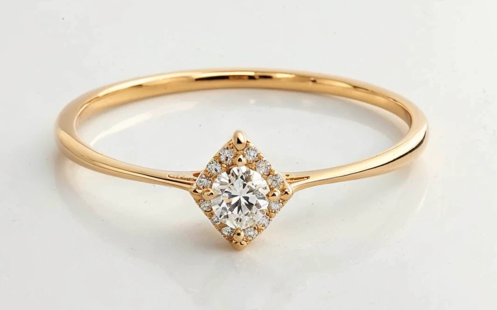 Anillo de promesa en oro amarillo 18k con piedra central redonda y halo de piedras, engaste rombo, diseño delicado