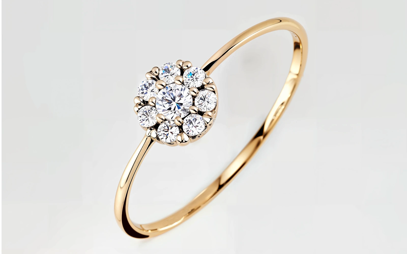 Anillo de promesa en oro amarillo 18k con cluster de diamantes redondos, diseño floral delicado y elegante.