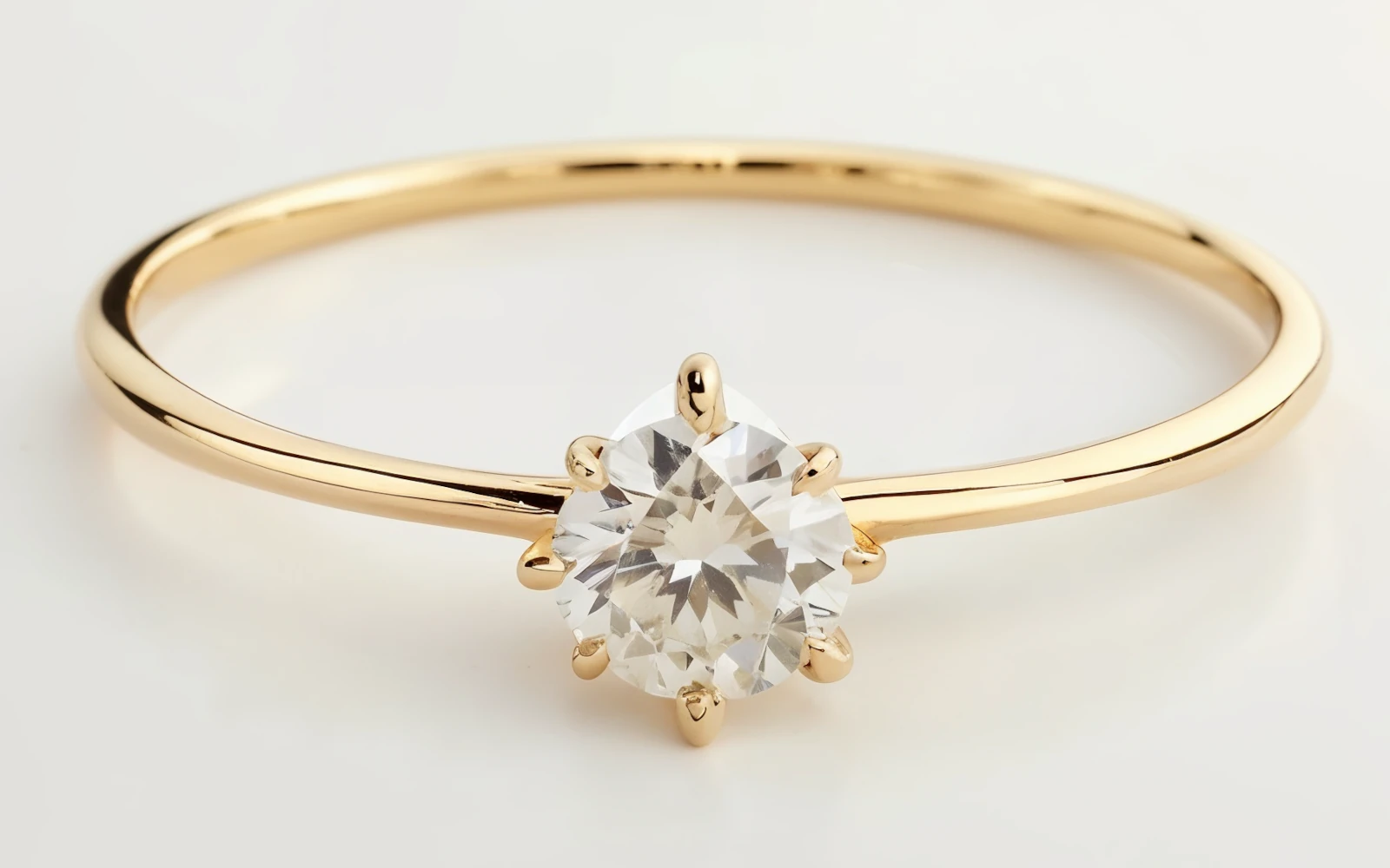 Anillo solitario en oro amarillo 18k con piedra central redonda engastada en seis garras clásicas.