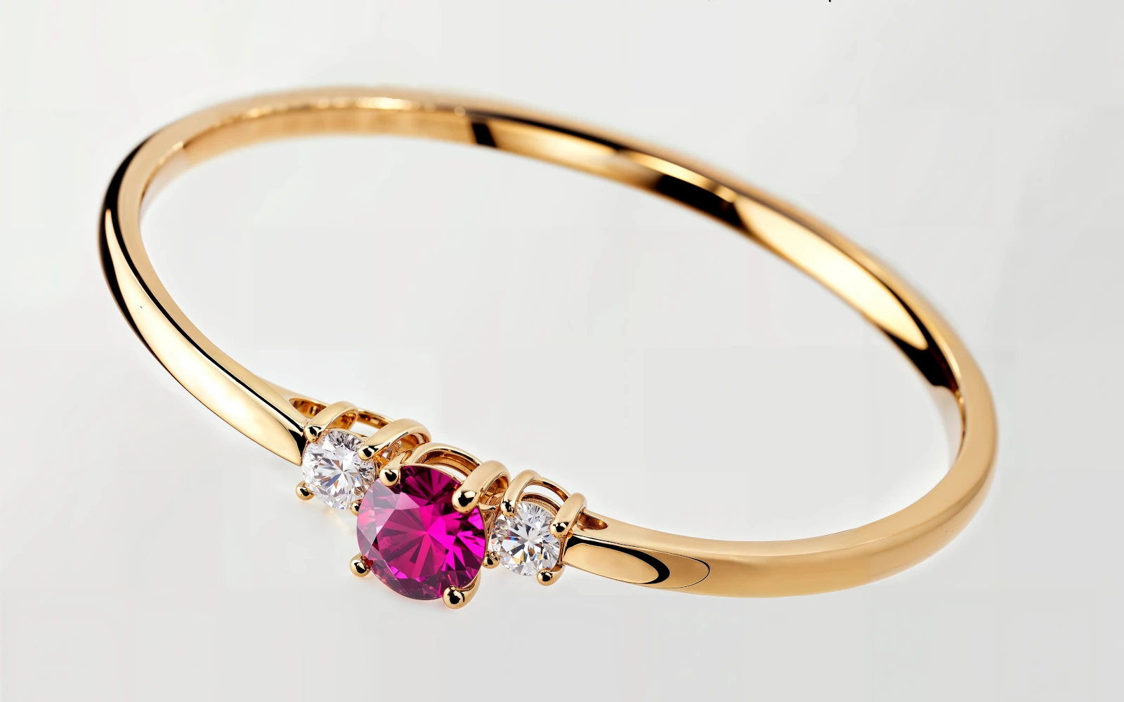 Anillo de promesa en oro amarillo 18k con piedra central color granate y dos piedras laterales engastados.