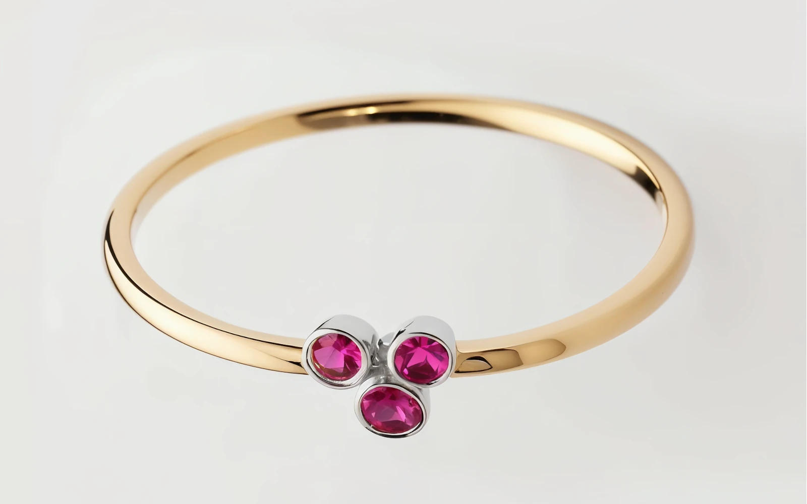 Anillo de promesa en oro amarillo 18k con tres piedras granates engastadas en bisel, diseño delicado y moderno.