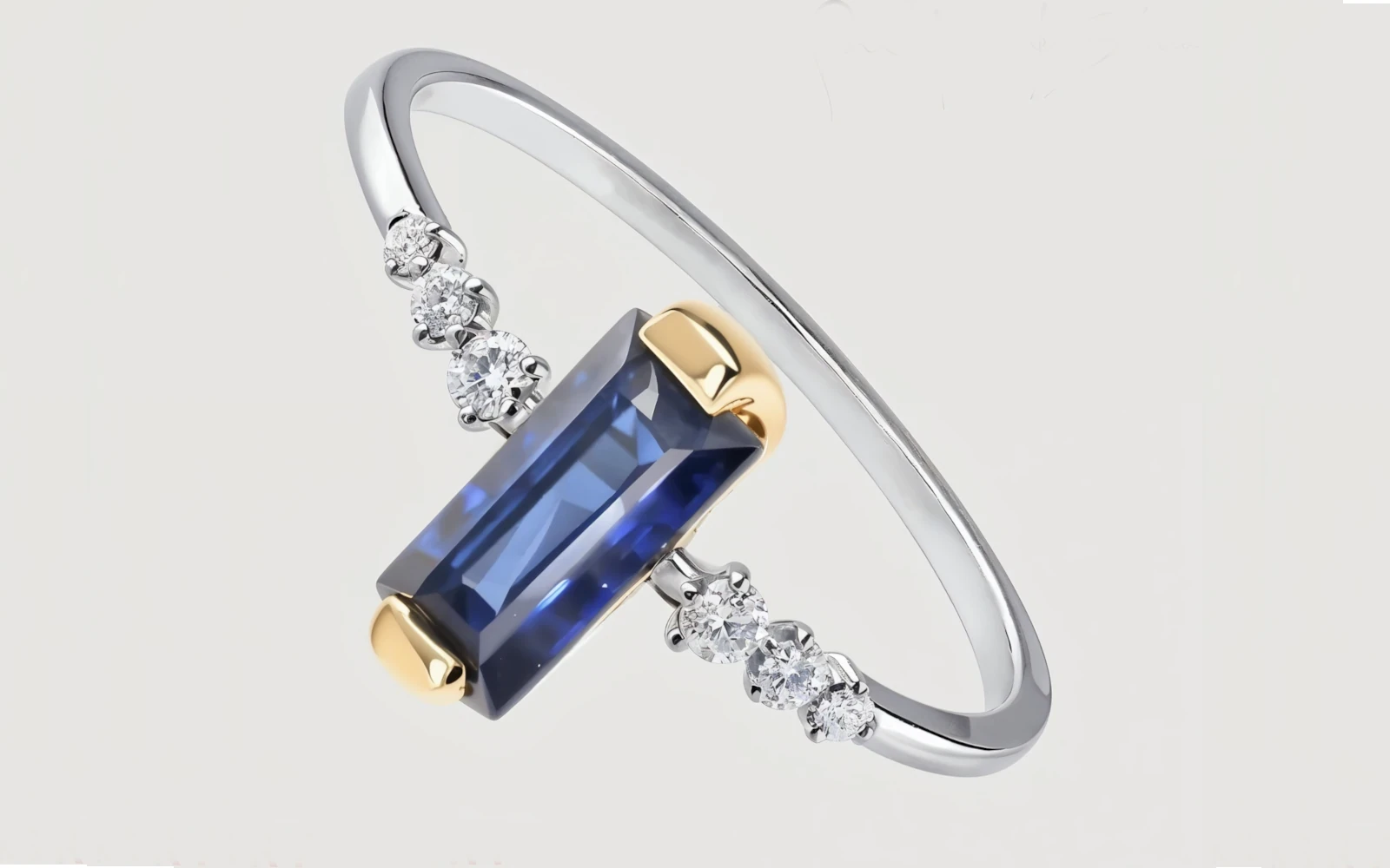 Anillo de promesa en oro 18k bicolor con piedra central azul rectangular y diamantes laterales, diseño contemporáneo.