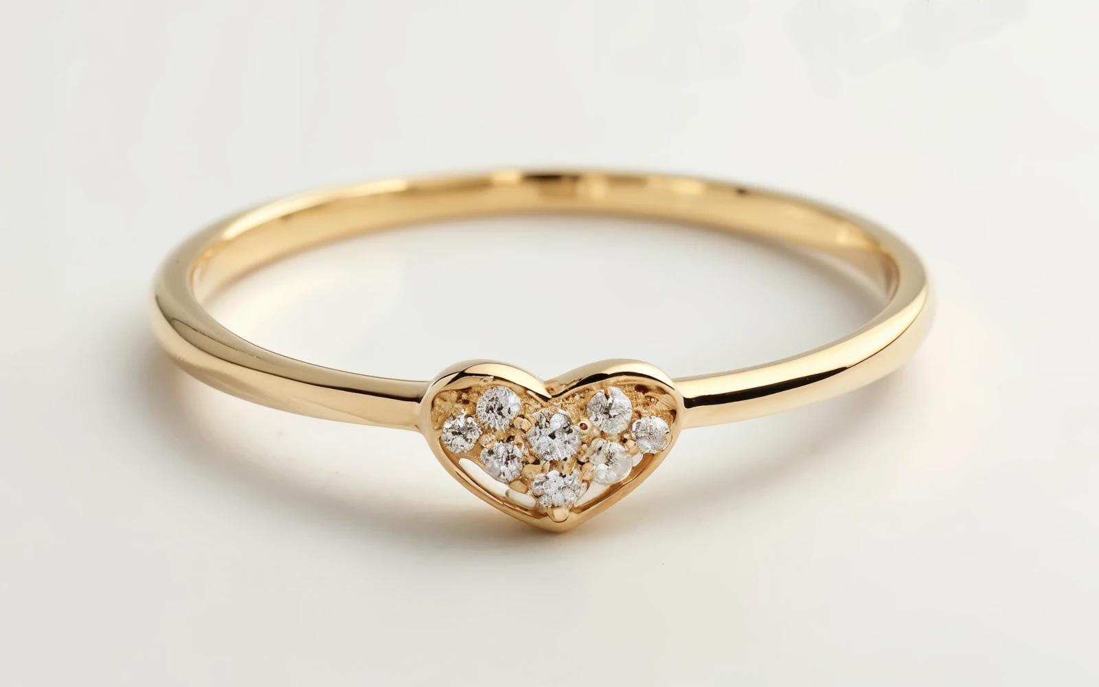 Anillo de promesa en oro amarillo 18k con corazón y pequeños diamantes engastados, diseño delicado y romántico.