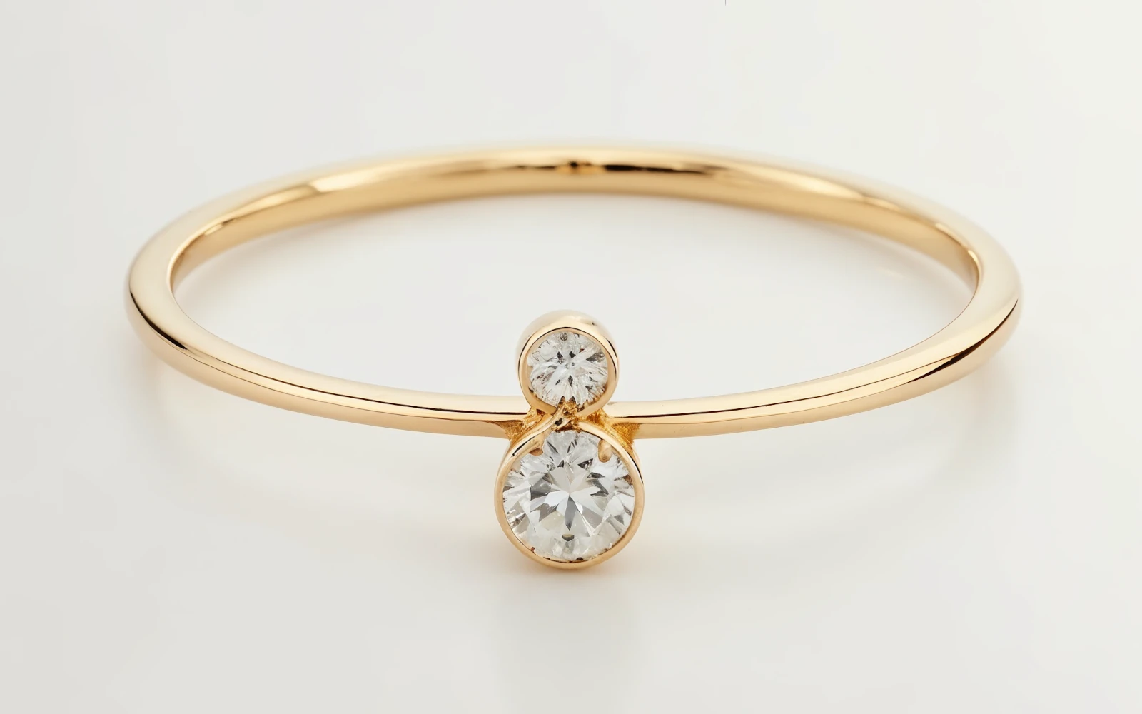 Anillo de promesa en oro amarillo 18k con dos piedras redondos en disposición vertical y diseño minimalista.