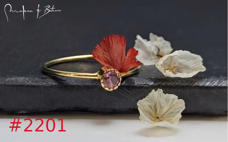  Anillo de oro con una pequeña piedra rosa y un adorno floral rojo. Número de artículo: #2201.