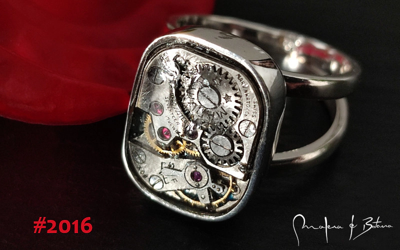Primer plano de un anillo de plata con un mecanismo de reloj suizo vintage visible, modelo #2016 de Malena de Botana.