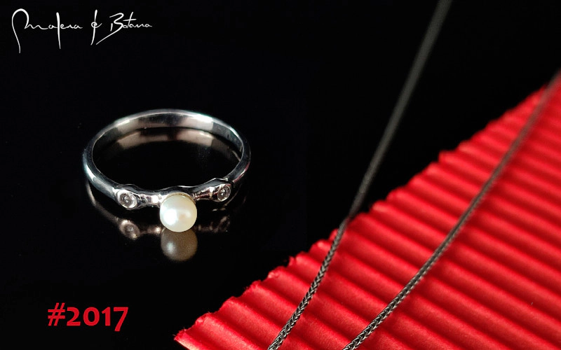 Imagen de un anillo de plata con una perla blanca como pieza central y dos circonitas a los lados, modelo #2017 de Malena de Botana.