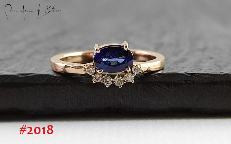 Anillo de oro rosa con un zafiro azul ovalado central y una pavé de diamantes, modelo #2018 de Malena de Botana.