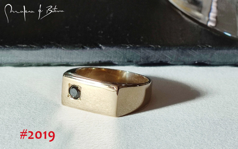 Imagen de un anillo de oro amarillo con un diamante negro engastado en una placa rectangular, modelo #2019 de Malena de Botana.