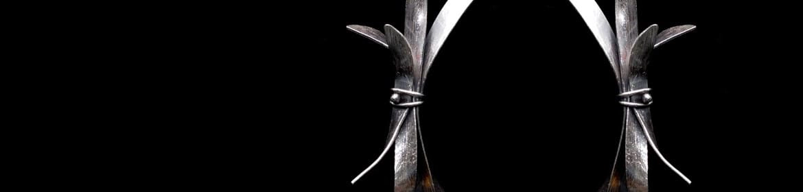 Par de pendientes de diseño contemporáneo que evocan formas orgánicas abstractas, posiblemente inspiradas en la naturaleza. La imagen, sobre un fondo negro, resalta las líneas y texturas de las piezas, ilustrando las tendencias innovadoras y artísticas que se exploran en el post Joyería Contemporánea.