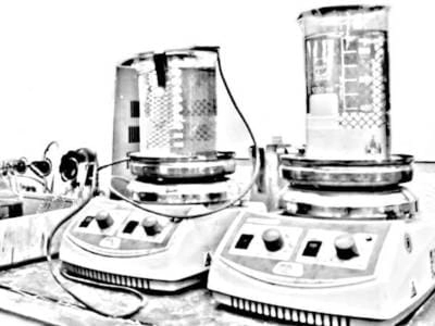 Imagen en blanco y negro de un conjunto de equipos de galvanoplastia, incluyendo tanques de electrolito y unidades de control, utilizados en el proceso de baño de rodio para joyería