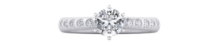 nillo de compromiso con una montura engastada con múltiples diamantes que rodea un diamante central brillante.