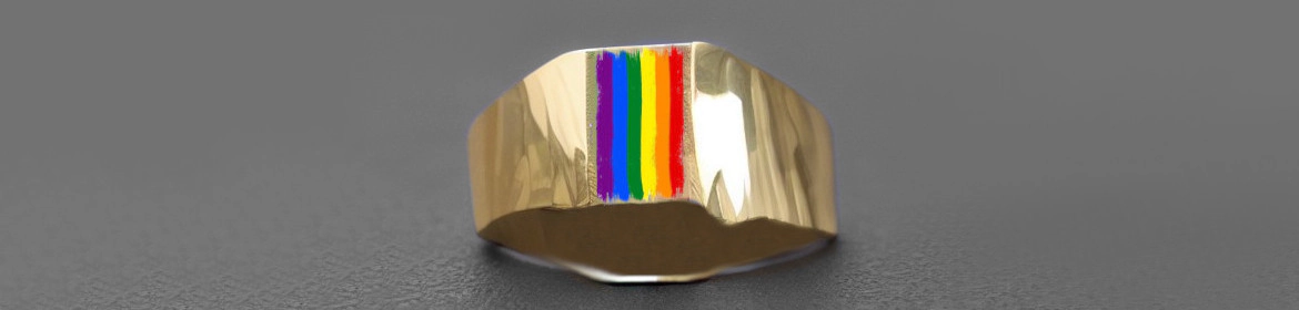 Un anillo de oro con una representación de la bandera del Orgullo LGBTQ+ en su superficie. El anillo tiene una banda ancha y plana, y la bandera está colocada verticalmente en el centro. El fondo es gris oscuro, lo que hace que el anillo dorado y los colores del arco iris destaquen.