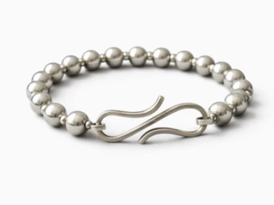 Pulsera de plata artesanal con diseño moderno sobre tela negra elegante