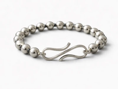 Pulsera de plata artesanal con cierre curvado elegante sobre fondo negro satin