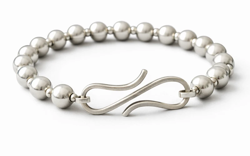 Pulsera de plata artesanal con diseño moderno sobre tela negra elegante